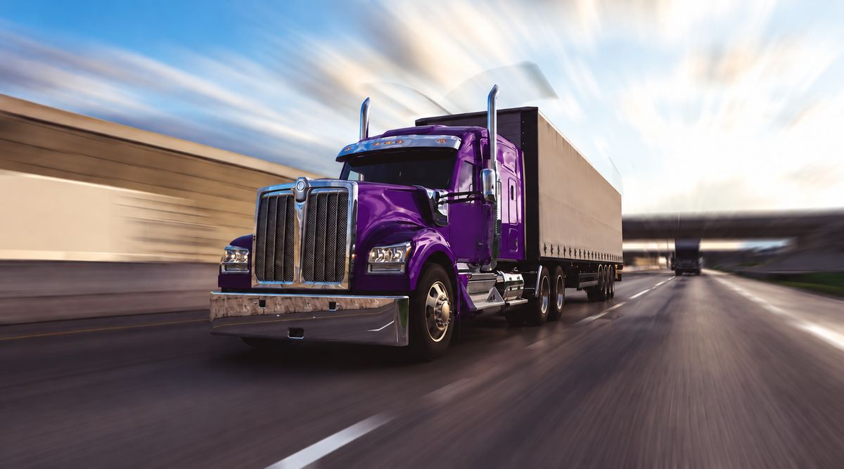 Frente y cabina de un tractocamión morado en movimiento